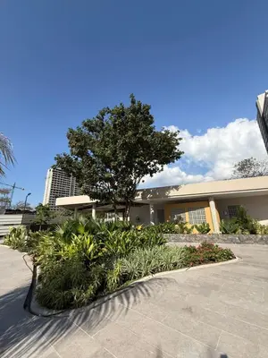 a building with a tree and plants in front of it at Nuevo Loft santa Marta vista al mar piso 18 in Santa Marta