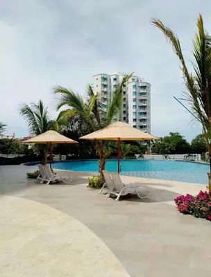 a pool with chairs and umbrellas and a building at Nuevo Loft santa Marta vista al mar piso 18 in Santa Marta