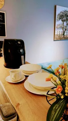 a table with plates and a coffee maker and a vase of flowers at Apartamento en Cartagena cerca al Mar in Cartagena de Indias