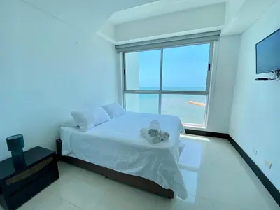 a bedroom with a bed and a large window at 2Br apartment in front of the beach in Cartagena de Indias
