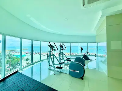 a gym with cardio equipment in a building with the ocean at 2Br apartment in front of the beach in Cartagena de Indias