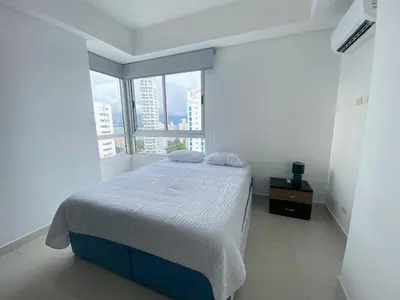 a bedroom with a bed and a large window at 2Br apartment in front of the beach in Cartagena de Indias