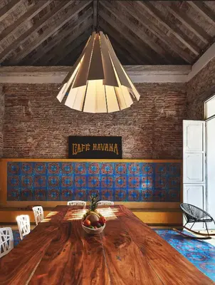 a dining room with a large wooden table and a chandelier at NOK Award Winning 4BR Villa wih pool at Getsemani in Cartagena de Indias