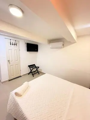 a bedroom with a white bed and a tv at Hotel CARTAGENA ES in Cartagena de Indias