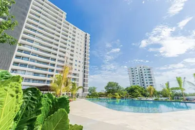 a swimming pool in front of a tall building at Apartamento en Santa Marina in Santa Marta
