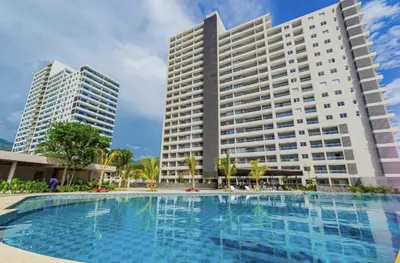 a large swimming pool in front of two tall buildings at Apartamento en Santa Marina in Santa Marta