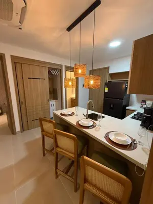 a kitchen with a large island with chairs and a sink at Luxy 2BR at paradise Oasis, 18 min from walled city in Cartagena de Indias