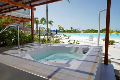 a hot tub on a patio next to the beach at Luxy 2BR at paradise Oasis, 18 min from walled city in Cartagena de Indias
