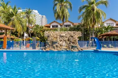 a pool at a resort with a water slide at Casa en conjunto cerrado, frente al mar in Santa Marta