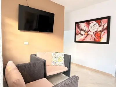 a living room with a couch and a tv on the wall at Casa Mercedes Cartagena in Cartagena de Indias