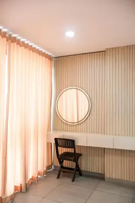 a chair in a room with a mirror and curtains at Tu Espacio Perfecto en el Norte de Barranquilla - Moderno y Amplio - Apto Dúplex in Barranquilla