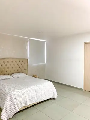 a white bedroom with a bed and a white wall at Tu Espacio Perfecto en el Norte de Barranquilla - Moderno y Amplio - Apto Dúplex in Barranquilla