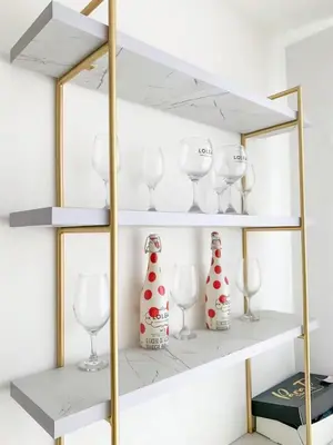 a shelf with wine glasses and vases on it at Tu Espacio Perfecto en el Norte de Barranquilla - Moderno y Amplio - Apto Dúplex in Barranquilla