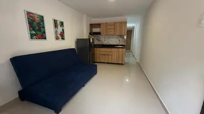 a living room with a blue couch and a kitchen at apartamento en Canapote cerca a la playa de Marbella in Cartagena de Indias