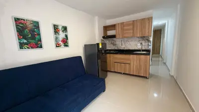 a living room with a blue couch and a kitchen at apartamento en Canapote cerca a la playa de Marbella in Cartagena de Indias