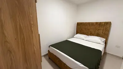 a small bedroom with a bed with a wooden headboard at apartamento cercano a la playa de Marbella Canapote in Cartagena de Indias