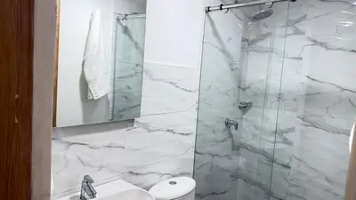 a bathroom with a shower with white marble tiles at apartamento cercano a la playa de Marbella Canapote in Cartagena de Indias