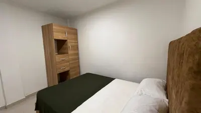 a bedroom with a bed and a wooden cabinet at apartamento cercano a la playa de Marbella Canapote in Cartagena de Indias