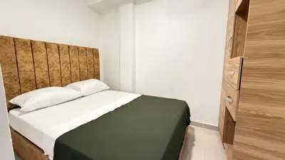 a bedroom with a bed with a wooden headboard at apartamento cercano a la playa de Marbella Canapote in Cartagena de Indias