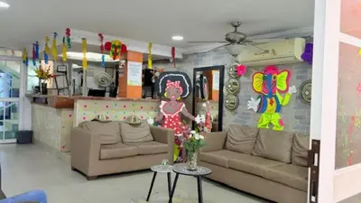 a living room with two couches and a wall with decorations at Hotel Avanty Barranquilla in Barranquilla