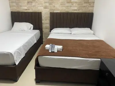 a bedroom with two twin beds with a watch on them at Hotel Avanty Barranquilla in Barranquilla