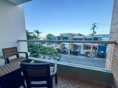 a balcony with a table and chairs and a view of a parking lot at Tu Refugio Perfecto en el Norte de Barranquilla - Cómodo, Moderno y Central in Barranquilla