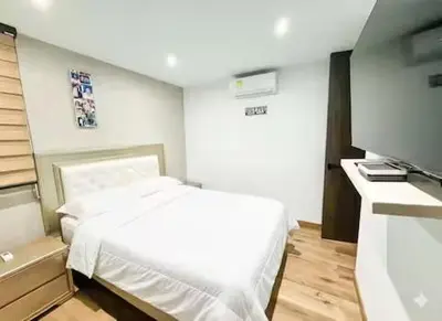 a bedroom with a white bed and a flat screen tv at Tu Refugio Perfecto en el Norte de Barranquilla - Cómodo, Moderno y Central in Barranquilla