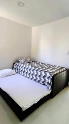 a bedroom with a bed with a black and white comforter at Brisa y Rio Apartamento en Norte Centro historico in Barranquilla