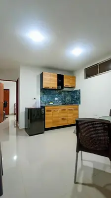 a kitchen with wooden cabinets and a black stove at Brisa y Rio Apartamento en Norte Centro historico in Barranquilla