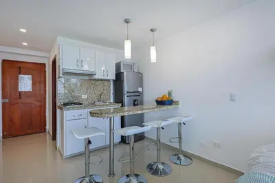 a kitchen with a counter and bar stools in it at Riviera Loft - Apartamento con vista al mar in Cartagena de Indias