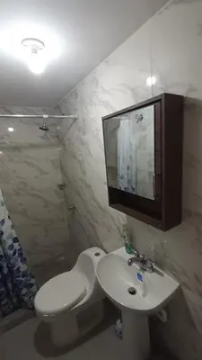 a bathroom with a toilet and a sink and a mirror at Apartamento Hermoso in Barranquilla