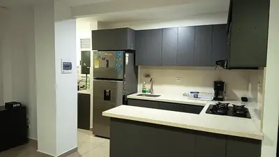 a kitchen with gray cabinets and a refrigerator at Apartamento Hermoso in Barranquilla