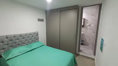 a bedroom with a bed with a green bedspread at Apartamento Hermoso in Barranquilla