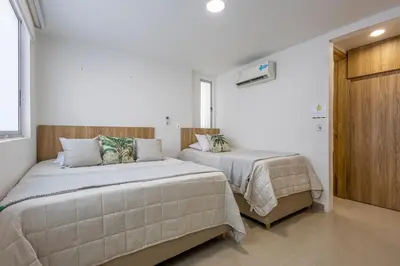 two beds in a room with white walls at Bocagrande Summer Beach - Primera linea de mar in Cartagena de Indias