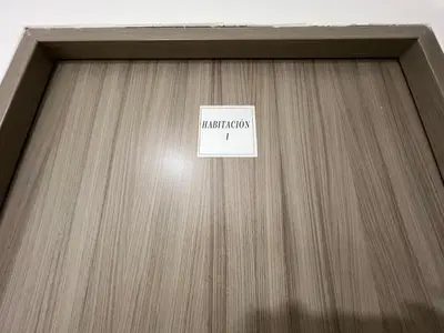 a sign on a wooden door with a sign on it at Habitación con baño privado cerca del carnaval de Barranquilla in Barranquilla
