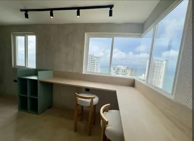 a kitchen with a counter and two chairs and a window at Apartamento en cartagena vista al mar in Cartagena de Indias