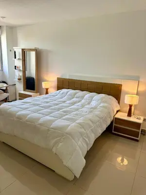 a large white bed in a bedroom with two lamps at Confort y Estilo en el Norte de Barranquilla in Barranquilla