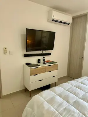 a bedroom with a bed and a tv on the wall at Confort y Estilo en el Norte de Barranquilla in Barranquilla