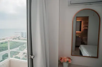 a mirror in a room with a bed and a window at Hermoso Apto Vista al Mar Céntrica ubicación in Cartagena de Indias