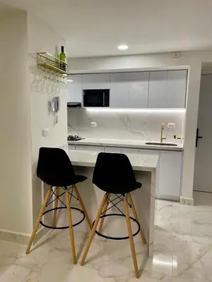 a kitchen with two black chairs at a counter at Hermoso Apto Vista al Mar Céntrica ubicación in Cartagena de Indias