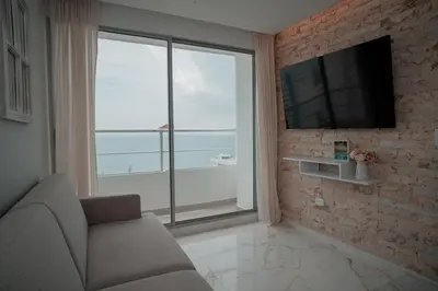 a living room with a couch and a large window at Hermoso Apto Vista al Mar Céntrica ubicación in Cartagena de Indias
