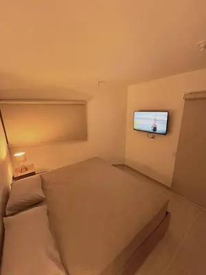 a bedroom with a bed and a flat screen tv at Charming Apartment Close to the Beach in Cartagena de Indias