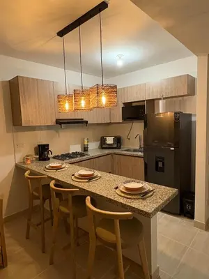 a kitchen with a table with chairs and a refrigerator at Charming Apartment Close to the Beach in Cartagena de Indias