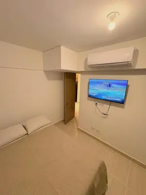 a bedroom with a bed and a tv on the wall at Charming Apartment Close to the Beach in Cartagena de Indias