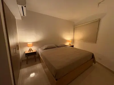 a bedroom with a bed and two lamps on tables at Charming Apartment Close to the Beach in Cartagena de Indias
