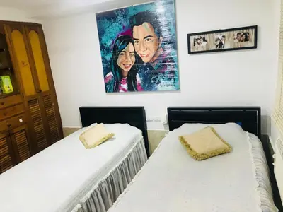 two beds in a room with a painting on the wall at The best room in Barranquilla! in Barranquilla