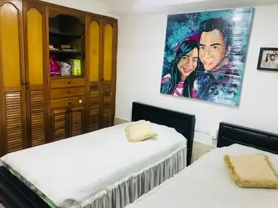 a bedroom with two beds and a painting on the wall at The best room in Barranquilla! in Barranquilla