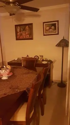 a dining room with a table and chairs and a lamp at hermosa habitacion in Barranquilla