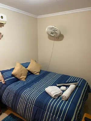 a bedroom with a bed with a fan on the wall at hermosa habitacion in Barranquilla
