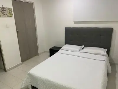 a bedroom with a large bed with white sheets at Posada encanto 2 cartagena in Cartagena de Indias
